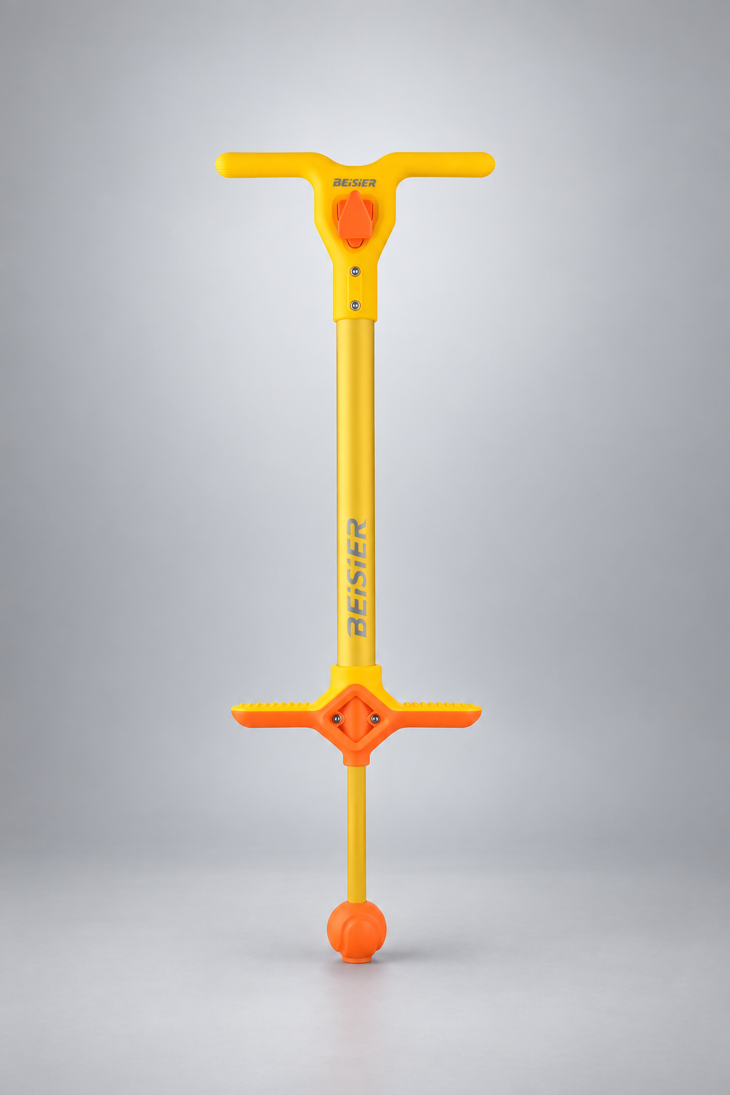 Yellow and orange kids pogo stick on a silver-gray studio background
