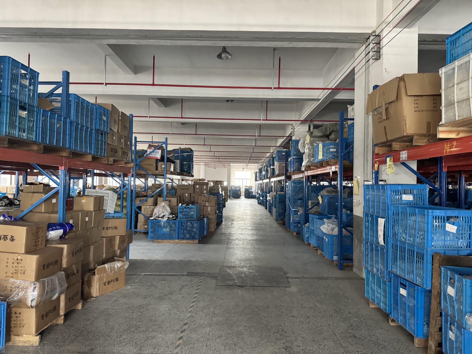 Organized warehouse aisle with scooter parts and production materials